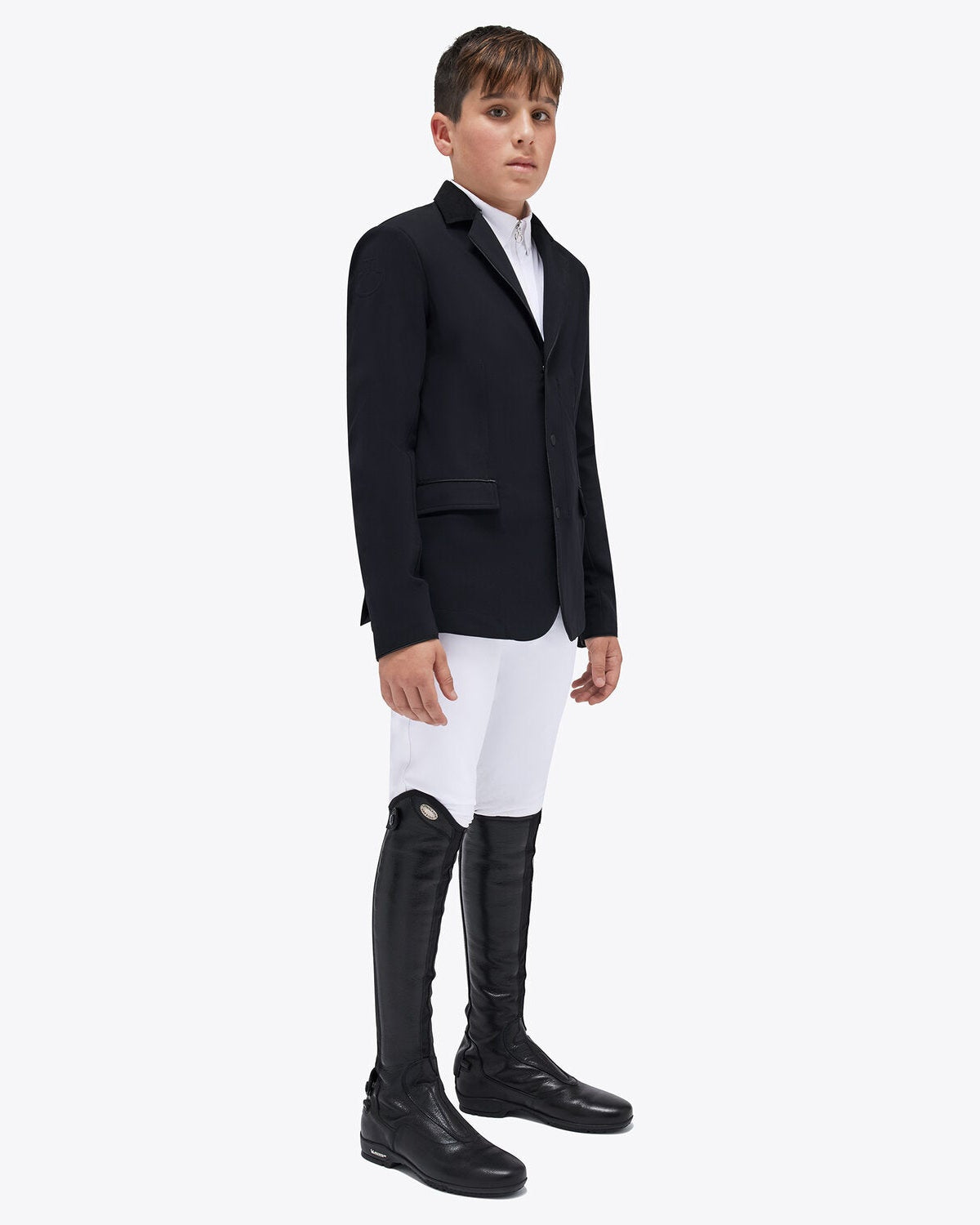 front view of a young rider wearing the Cavalleria Toscana CT Boys Competition Jacket With Zip, featuring a suede collar, tailored fit and buttoned cuffs.