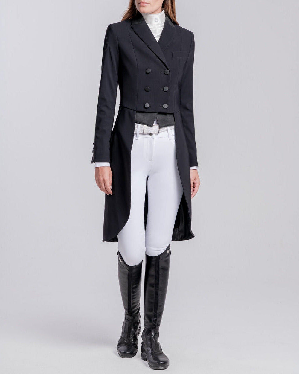 Cavalleria Toscana ladies black dressage tailcoat in 4-way stretch technical jersey, model wearing elegant dressage tails with white breeches and black riding boots. FRD018