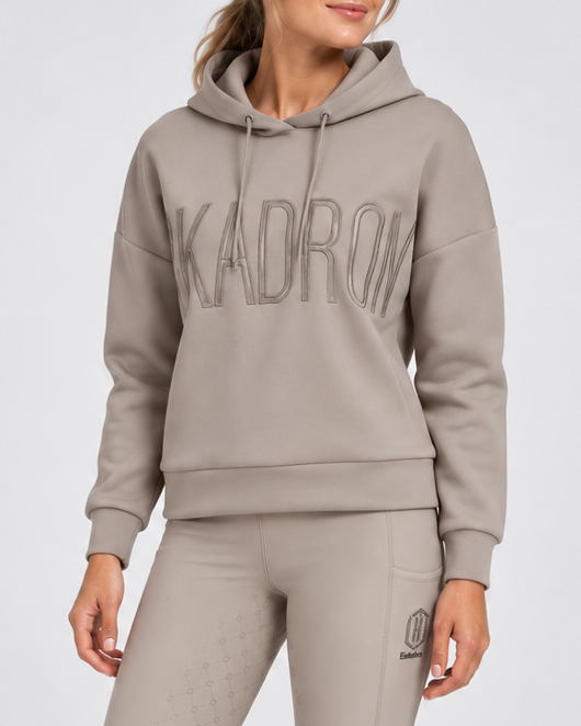 Eskadron Ladies Hoody Heritage 2026/27 in taupe grey, featuring tonal logo embroidery, relaxed fit and drawstring hood, styled with matching grey full grip riding breeches.