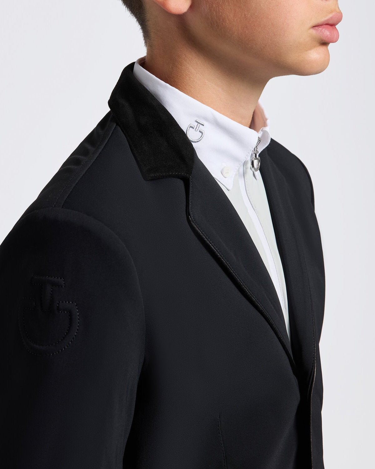 Close up of a young rider wearing the Cavalleria Toscana CT Boys Competition Jacket With Zip, featuring a suede collar, tailored fit and buttoned cuffs.