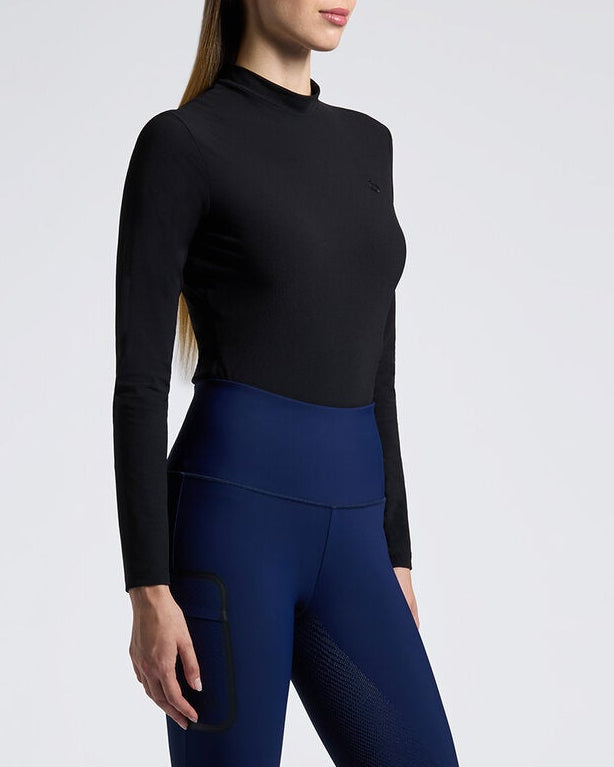 Person wearing a black top, blue leggings, and black riding boots on a white background
